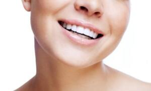 A woman smiling confidently with cosmetically enhanced teeth.