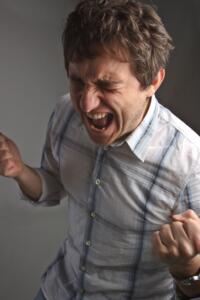 A man screaming in pain from an untreated dental infection.